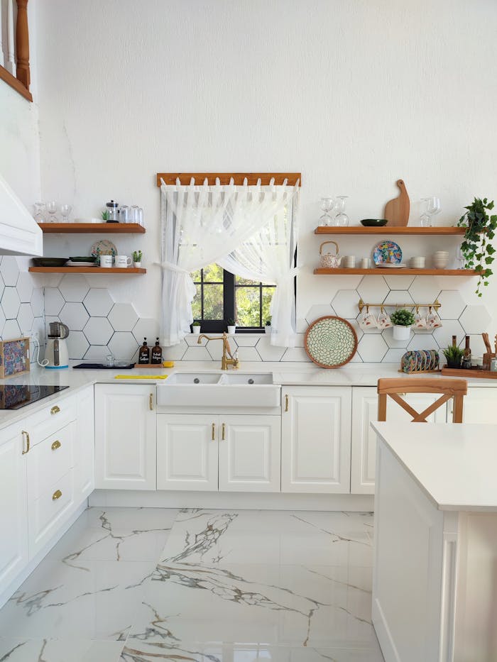 Spacious white kitchen featuring modern cabinetry and natural light.